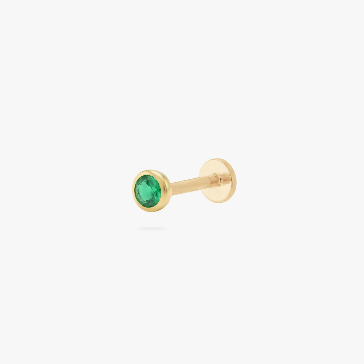 This is an image of a gold toned flatback stud with a 3mm, bezel set green CZ stone. 