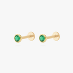 This is an image of a pair of gold toned flatback studs with 3mm, bezel set green CZ stones. 