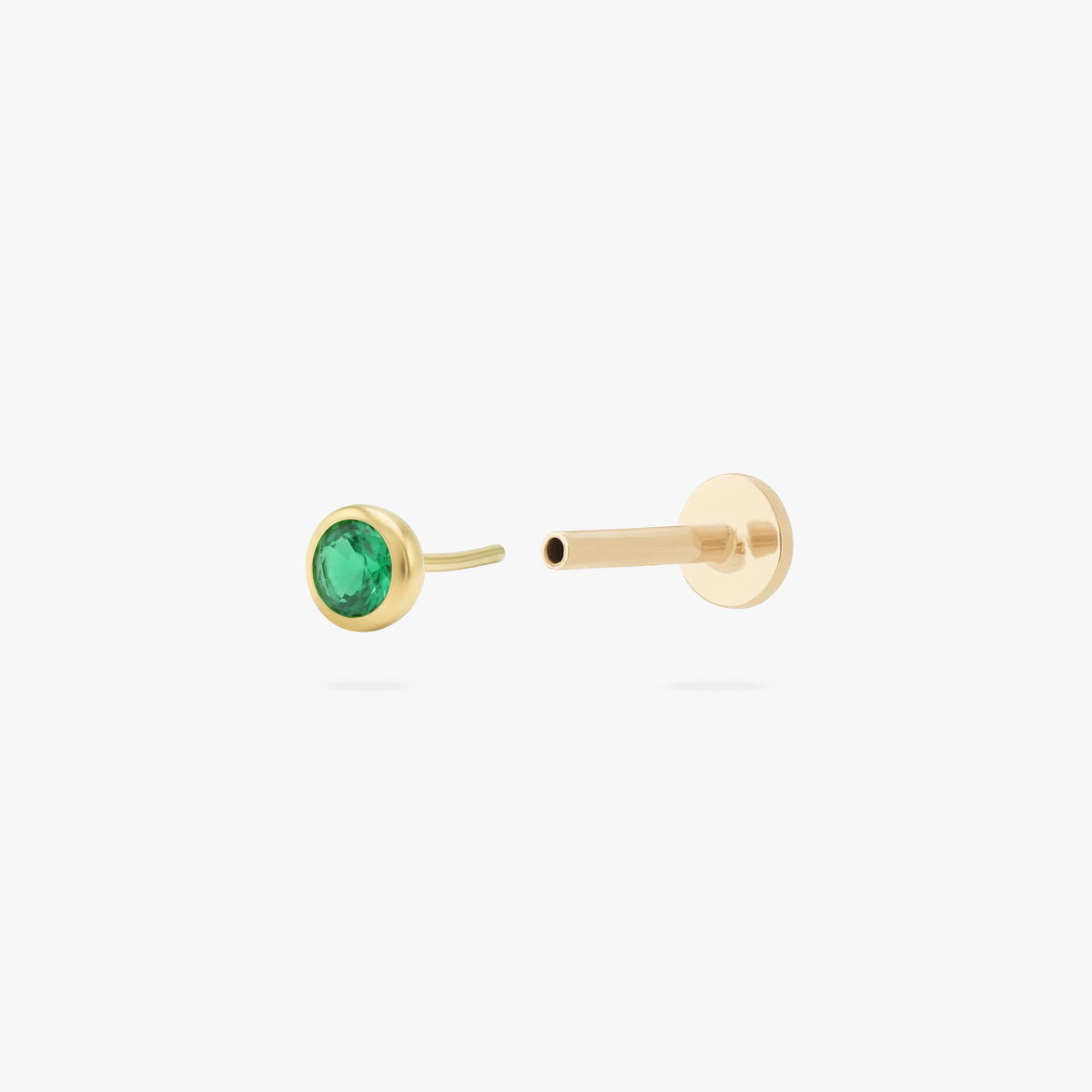 This is an image of a gold toned flatback stud with a 3mm, bezel set green CZ stone. 