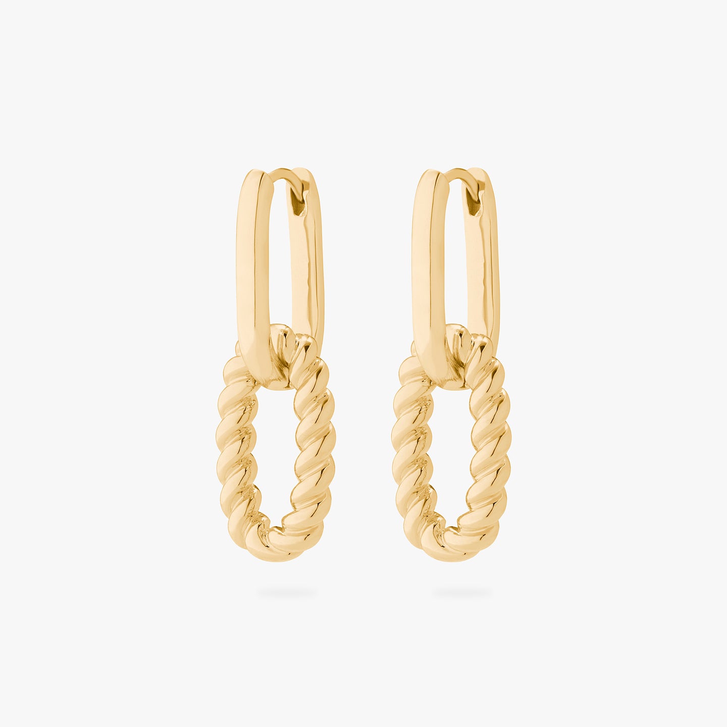 A pair of gold medium oval hoops with puffy twisted charms hanging from them. [pair] color:null|gold
