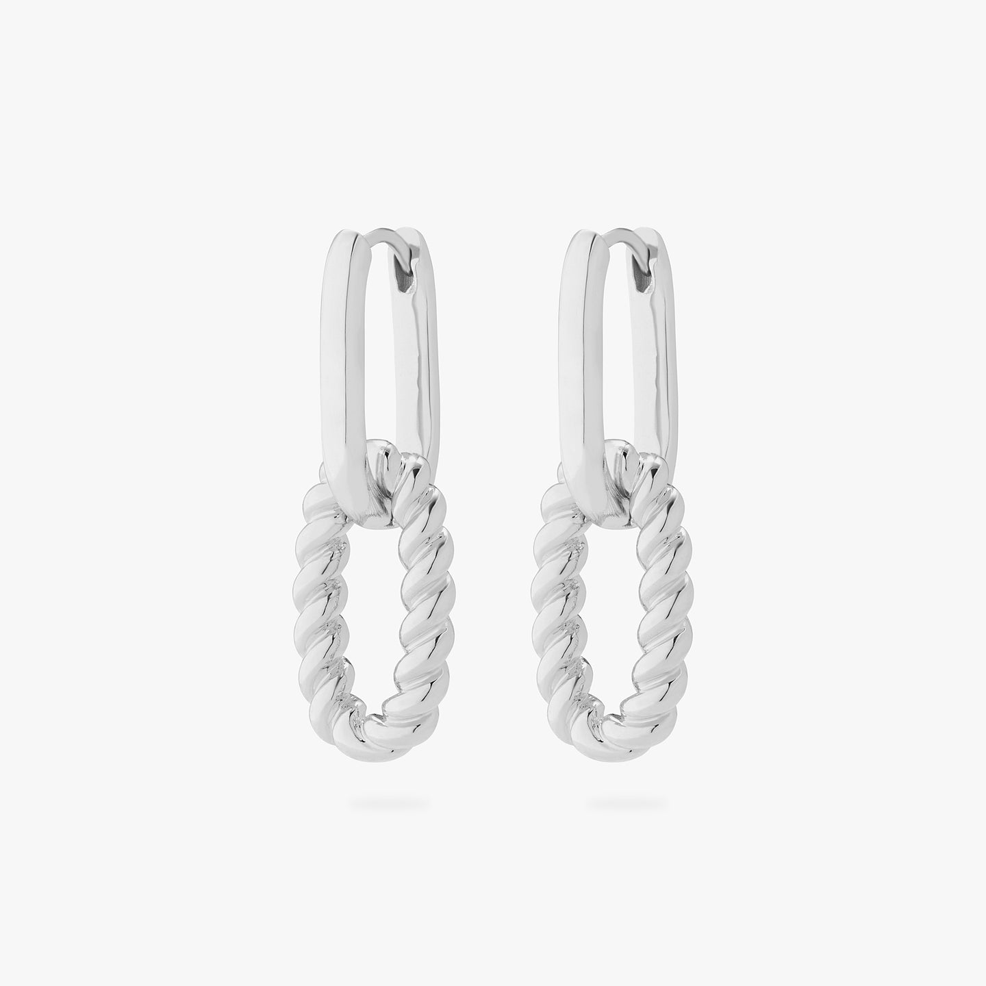 A pair of silver medium oval hoops with puffy twisted charms hanging from them. [pair] color:null|silver