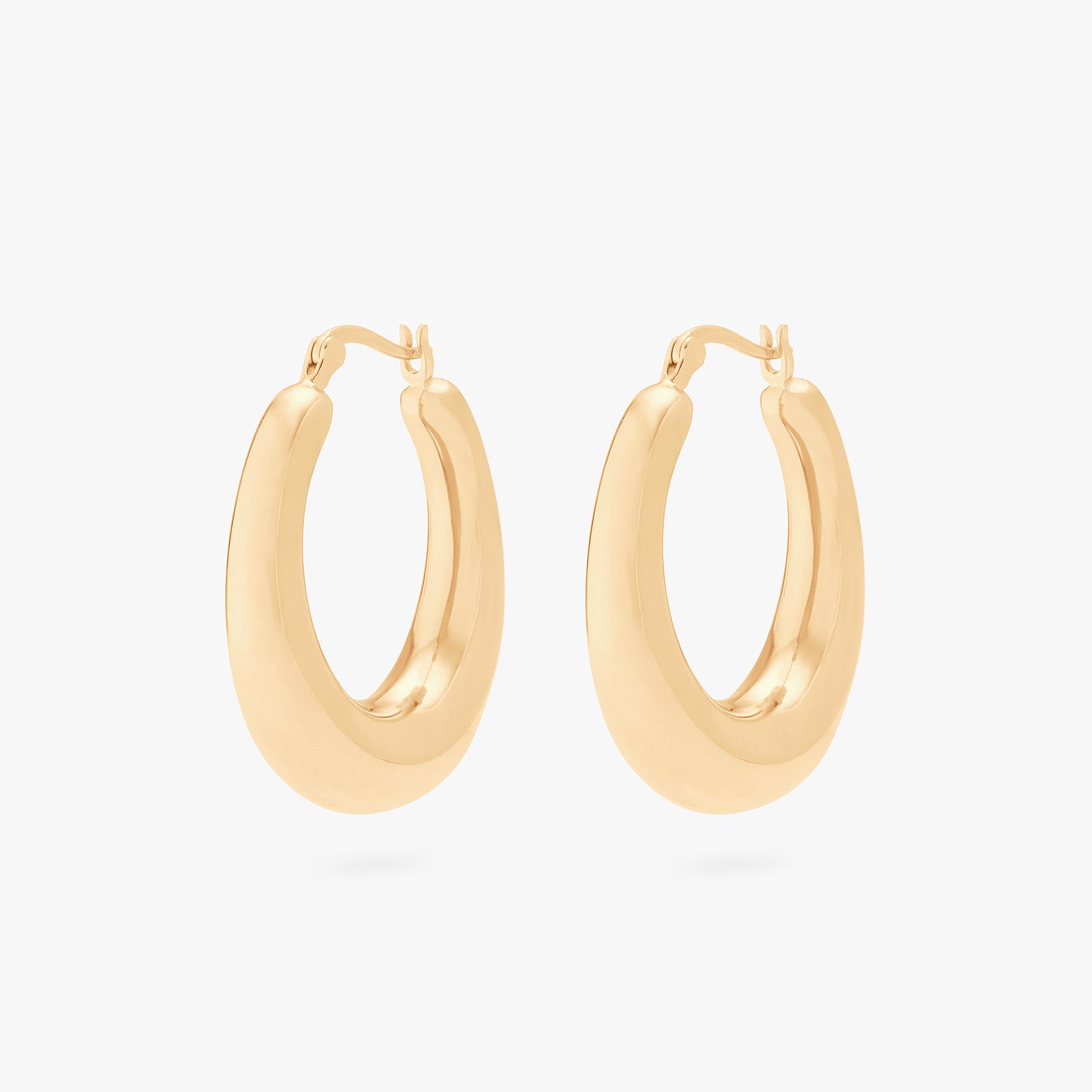 This is a pair of gold, medium-sized, oval crescent shaped hoops. [pair] color:null|gold