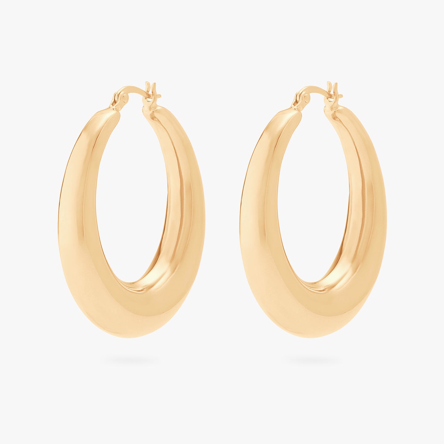 This is a pair of gold, large, oval crescent shaped hoops. [pair] color:null|gold