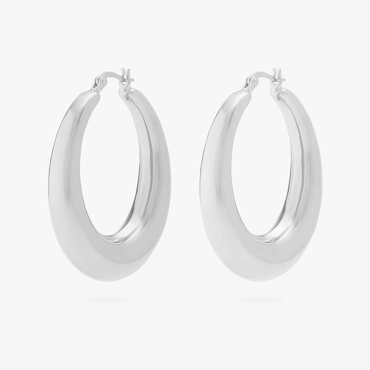 This is a pair of silver, large, oval crescent shaped hoops. [pair] color:null|silver