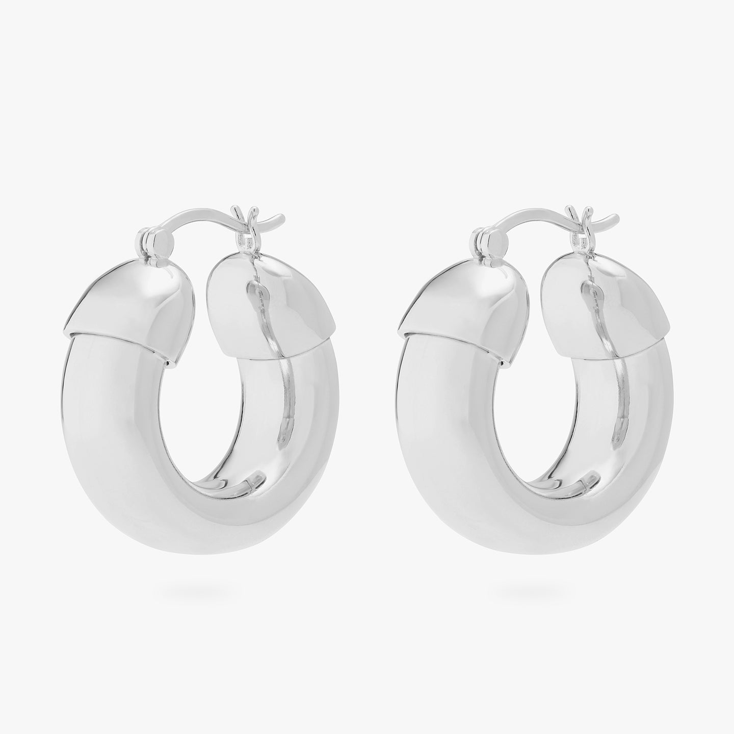 This is an image of a pair of silver, chunky tubed hoops. color:null|silver