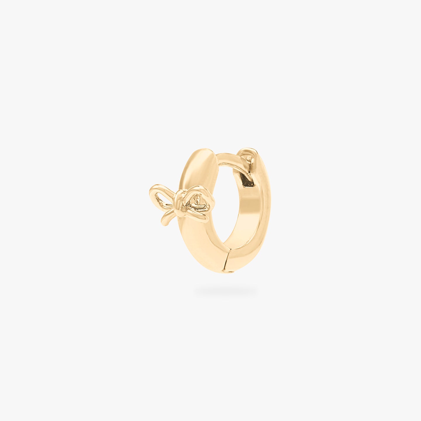 micro huggie with a small bow accent in gold color:null|gold