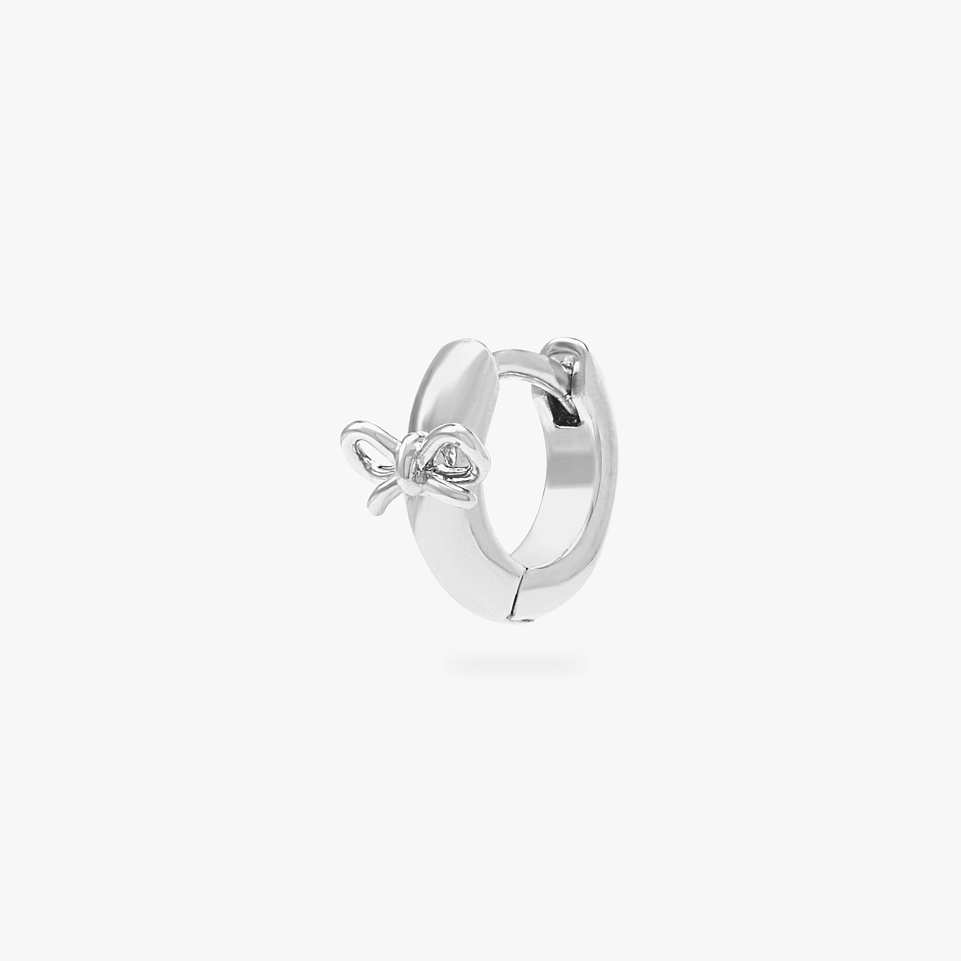 micro huggie with a small bow accent in silver color:null|silver