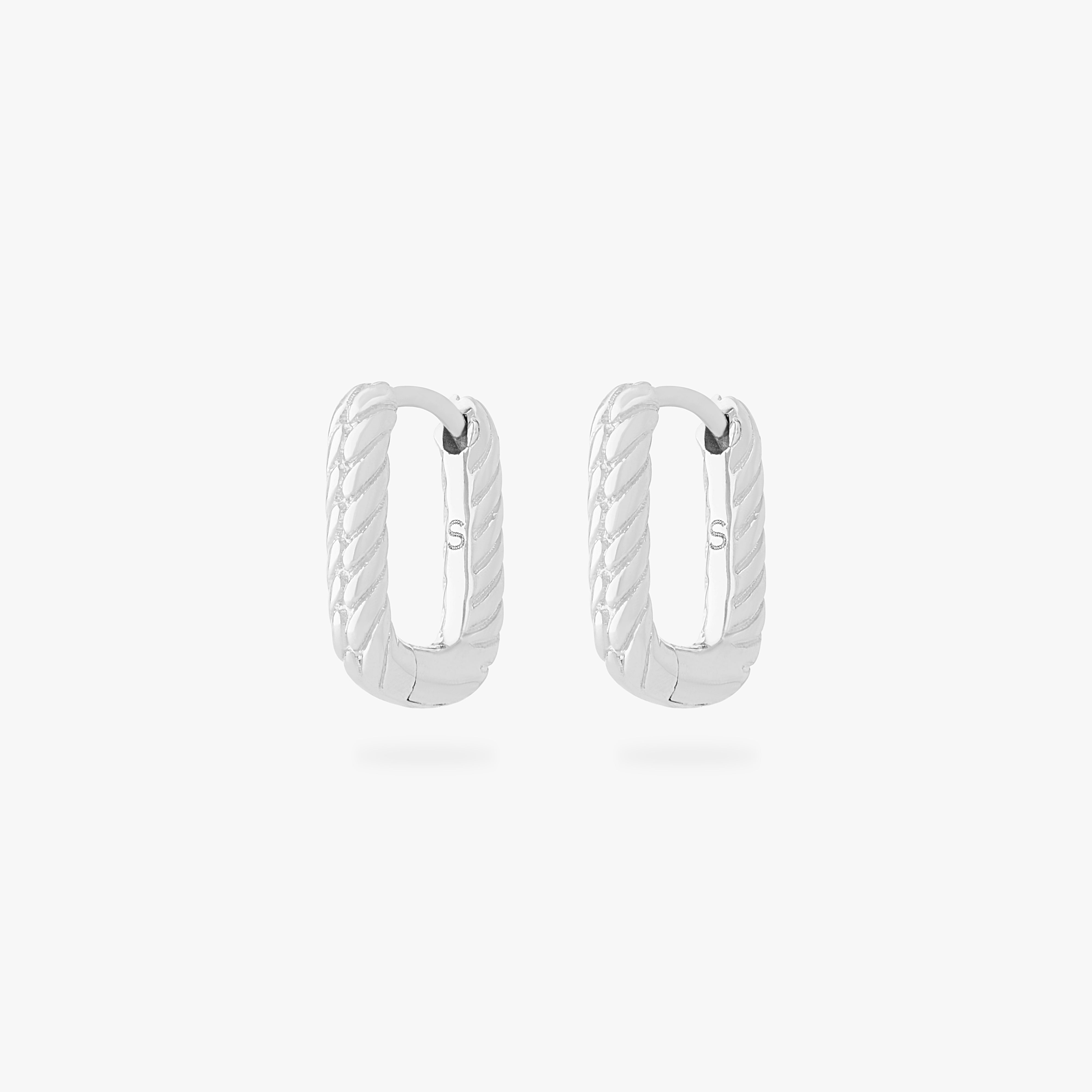 This is an image of a pair of silver-toned, square shaped huggies that have twists throughout them. [pair] color:null|silver