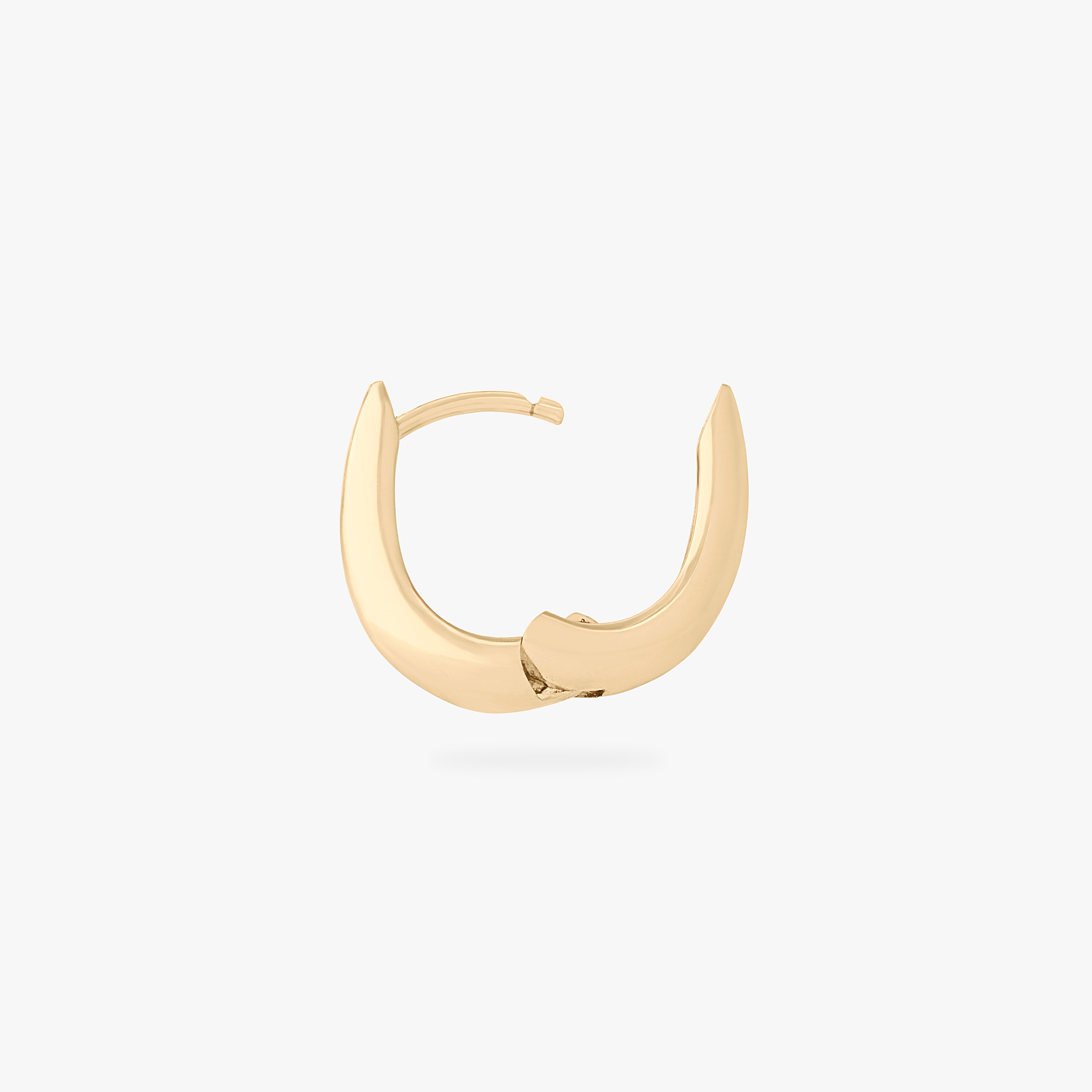 This is an image of a gold-toned, small, crescent shaped huggie. color:null|gold