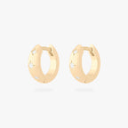 This is an image of a pair of gold-toned huggies with twinkle star shaped engravings with CZs in them. [pair] color:null|gold/clear