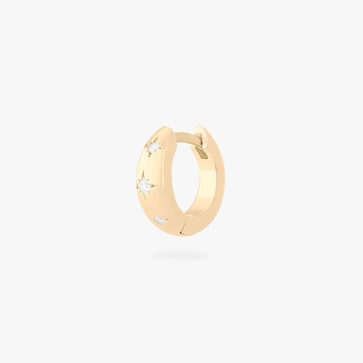 This is an image of a gold-toned huggie with twinkle star shaped engravings with CZs in them. color:null|gold/clear