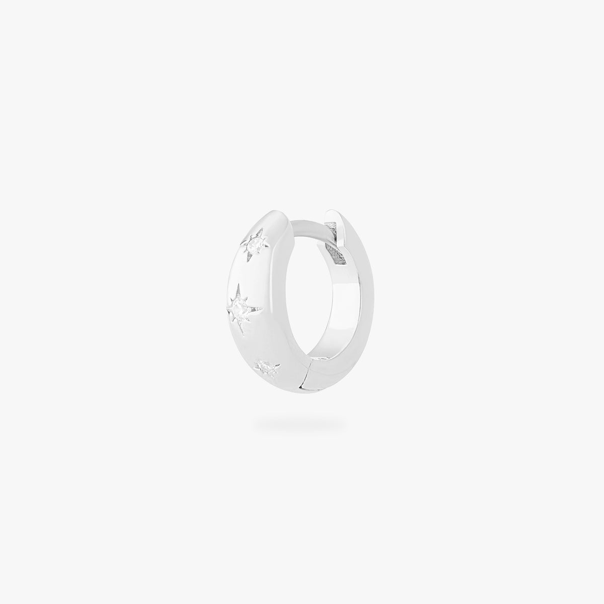 This is an image of a silver-toned huggie with twinkle star shaped engravings with CZs in them. color:null|silver/clear