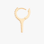 This image shows the side view of the 14k gold plated long pave spike huggie with cz clear stones down the front separated fron hinge
