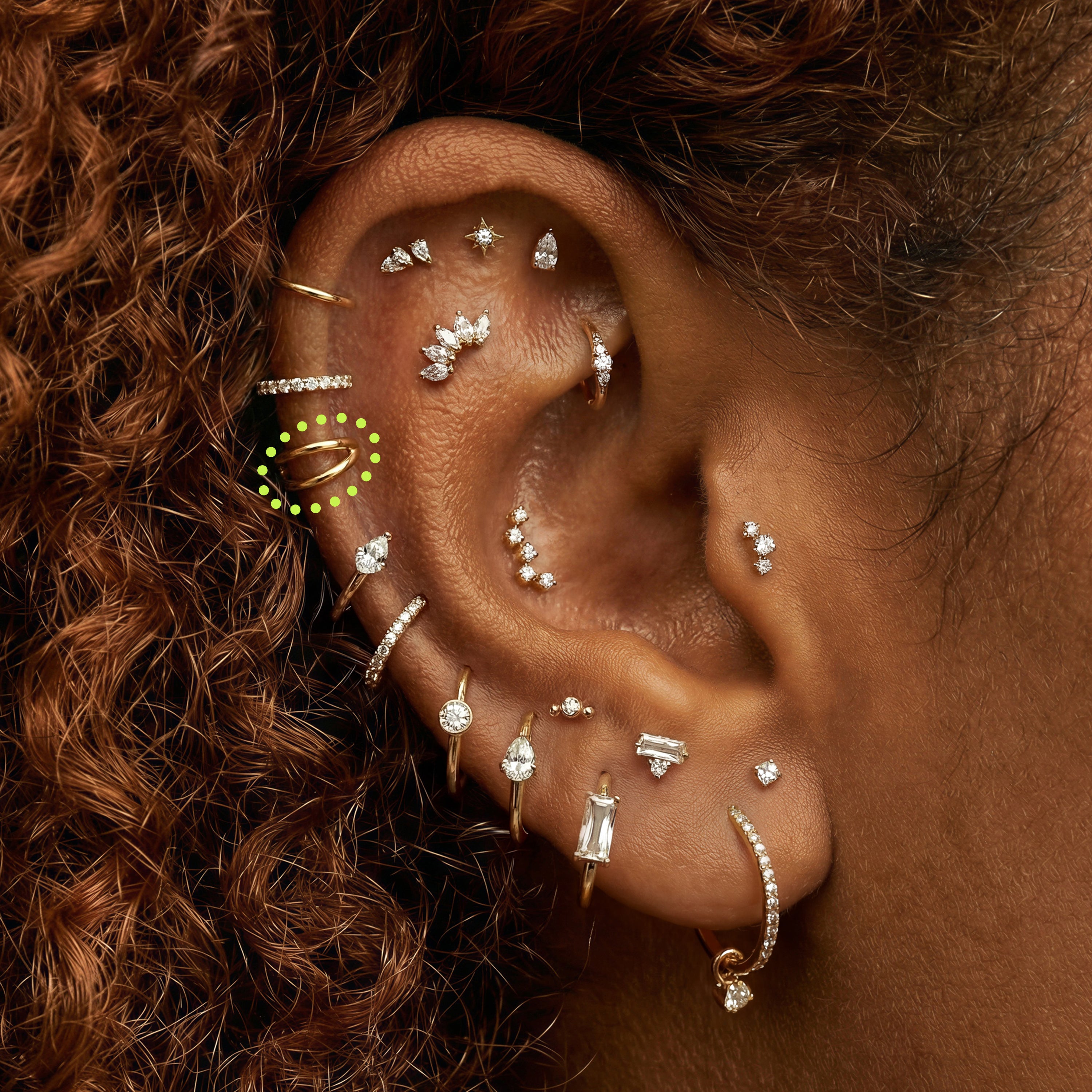 Close-up of an ear with multiple earrings  with a 5mm gold double clicker circled in the helix