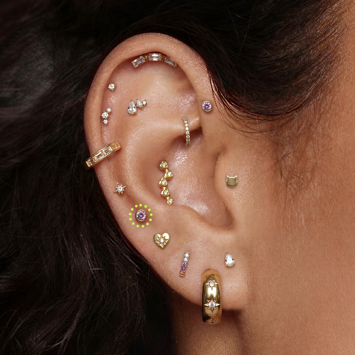 This is an image of a gold toned flatback stud with a 3mm, bezel set pink CZ stone circled on an ear.
