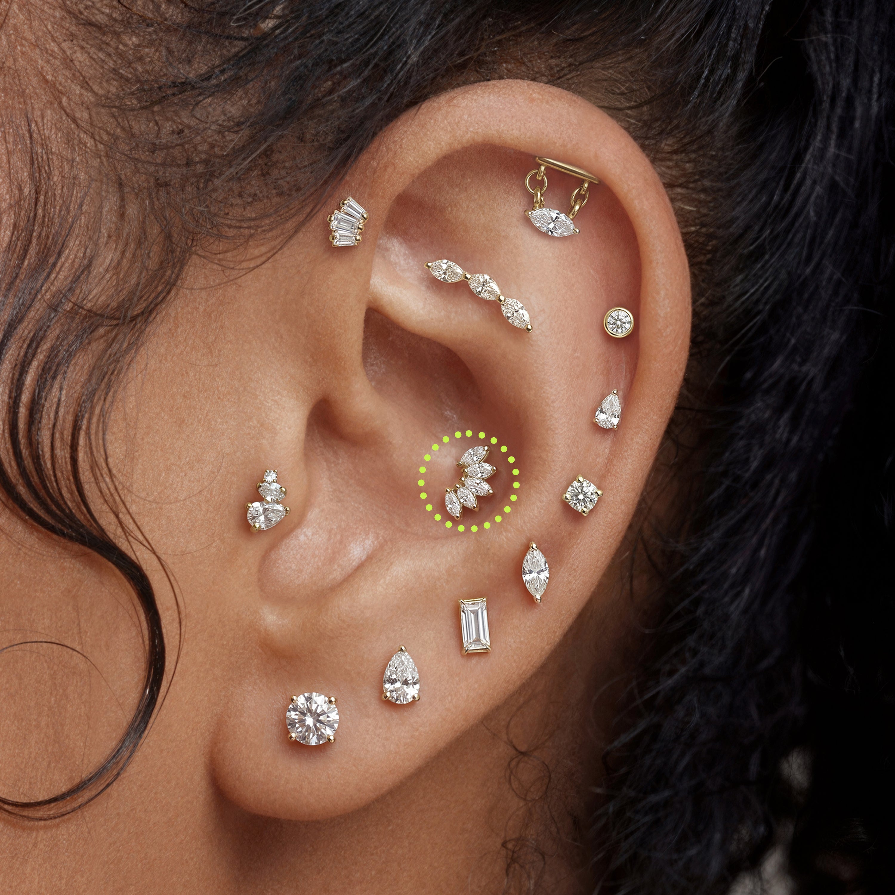 This is an image of a golden flatback stud with 5 marquise cut clear CZs in a crown formation on ear.