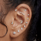 This is an image of a gold toned flatback stud with a 5mm clear, pear cut CZ circled on an ear.