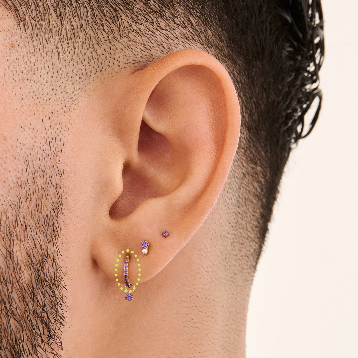 This is a gold toned clicker with amethyst cz stones on ear. [hover] color:null|amethyst