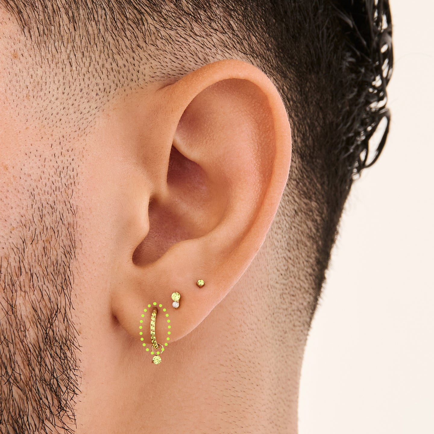 This is a gold toned clicker with peridot cz stones on ear. [hover] color:null|peridot