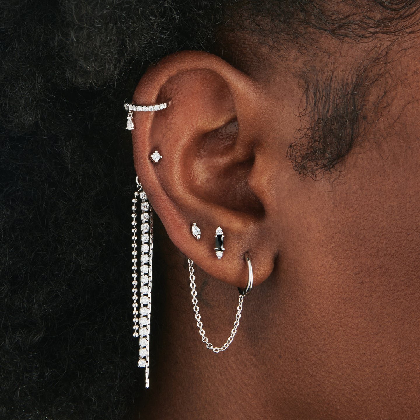 An image of a silver butterfly earring back that has pave chain charms in silver soldered to it with a mini CZ stud in silver/clear on ear. [hover] color:null|silver/clear