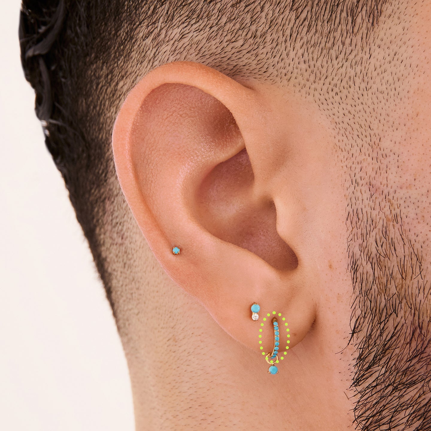 This is a gold toned clicker with turquoise cz stones on ear. [hover] color:null|turquoise