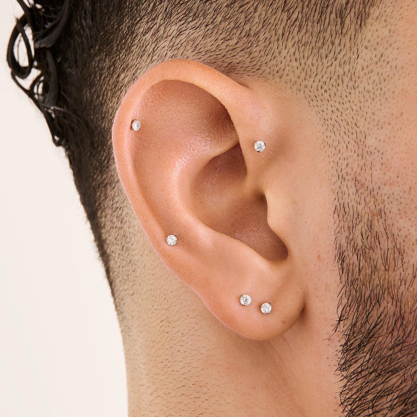 This image is a silver toned titanium flatback stud with a crystal cz stone on ear. [hover] color:null|crystal