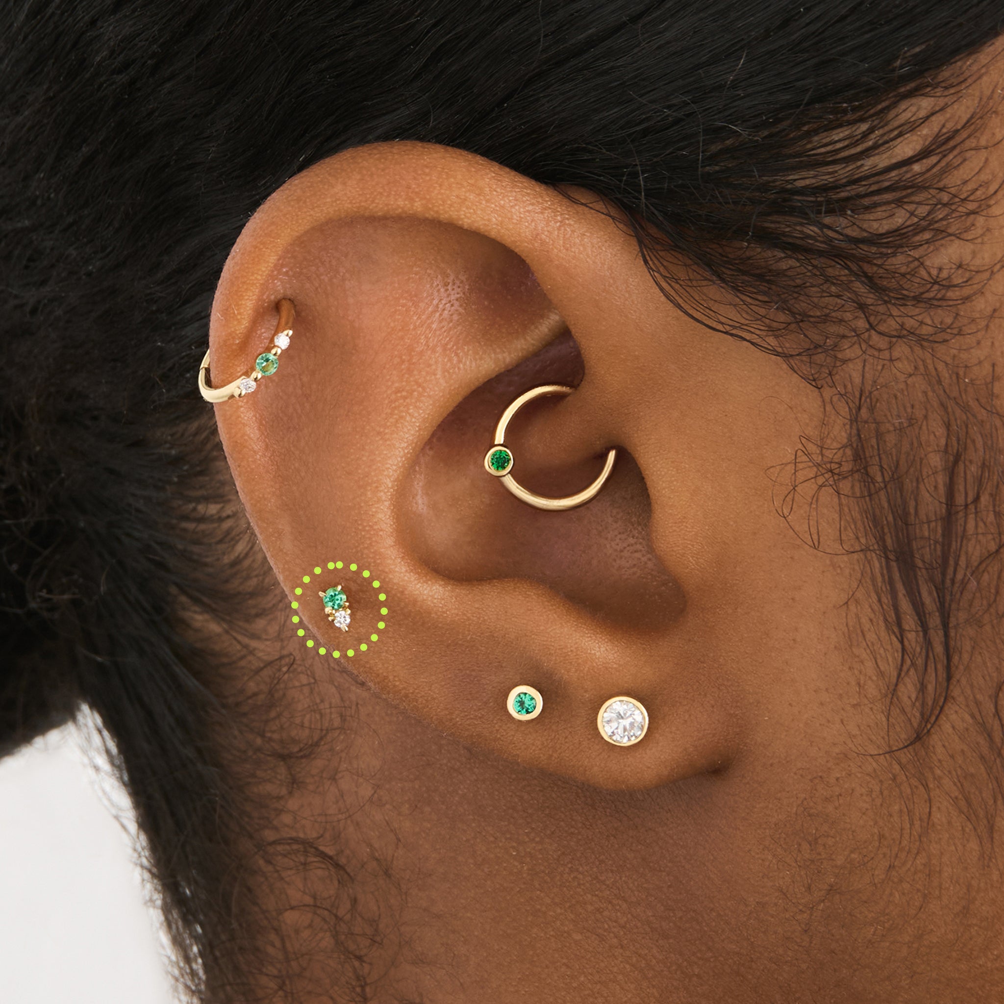 This is an image of a gold flatback stud with a green stacked cz stone on ear. [hover] color:null|14k gold/green