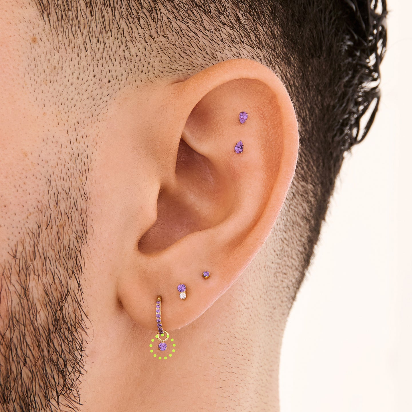 This is an image of a gold charm for a clicker that has a micro amethyst cz on it on ear. [hover] color:null|amethyst