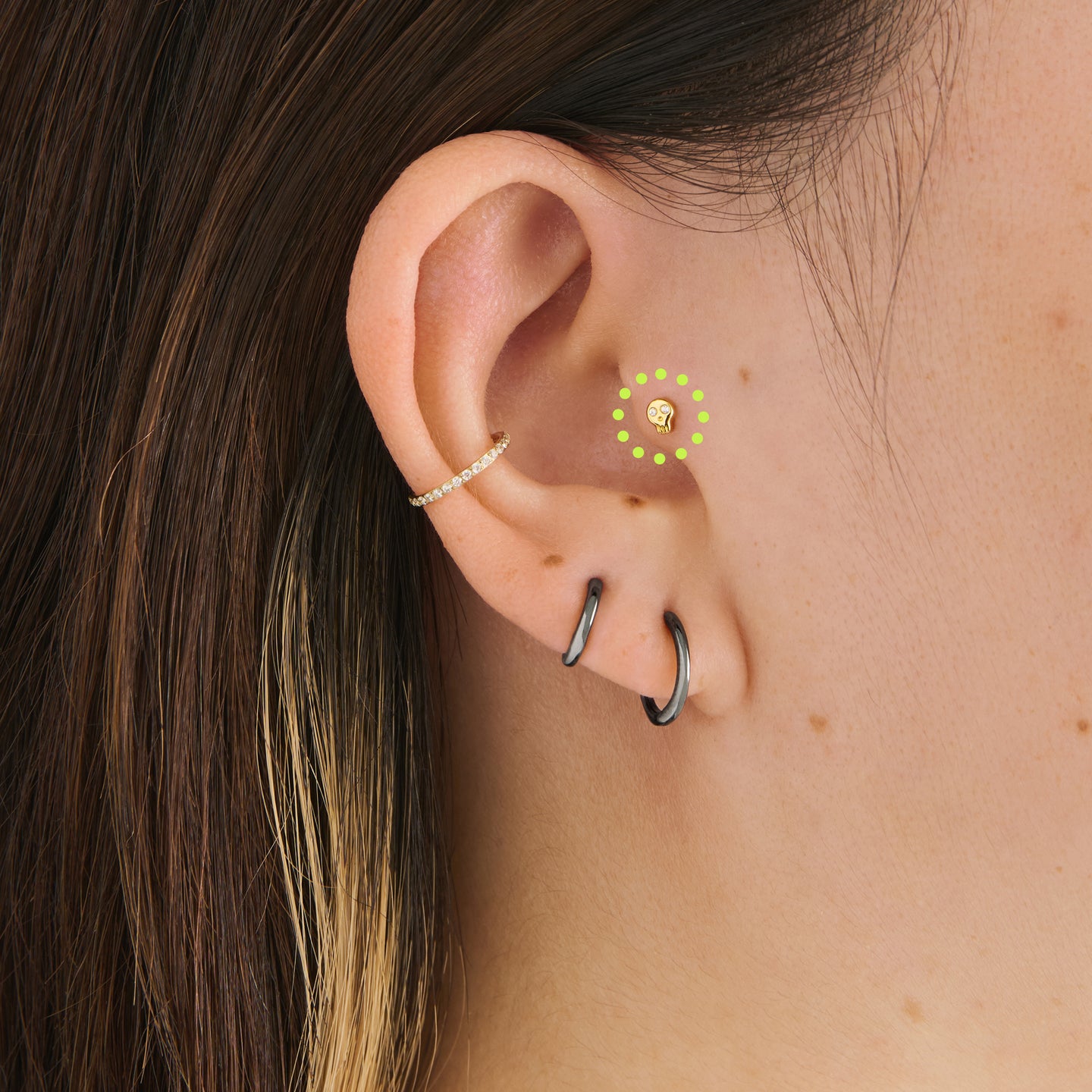 on ear featuring a micro cz skull stud in gold with cz accent eyes [hover] color:null|gold/clear