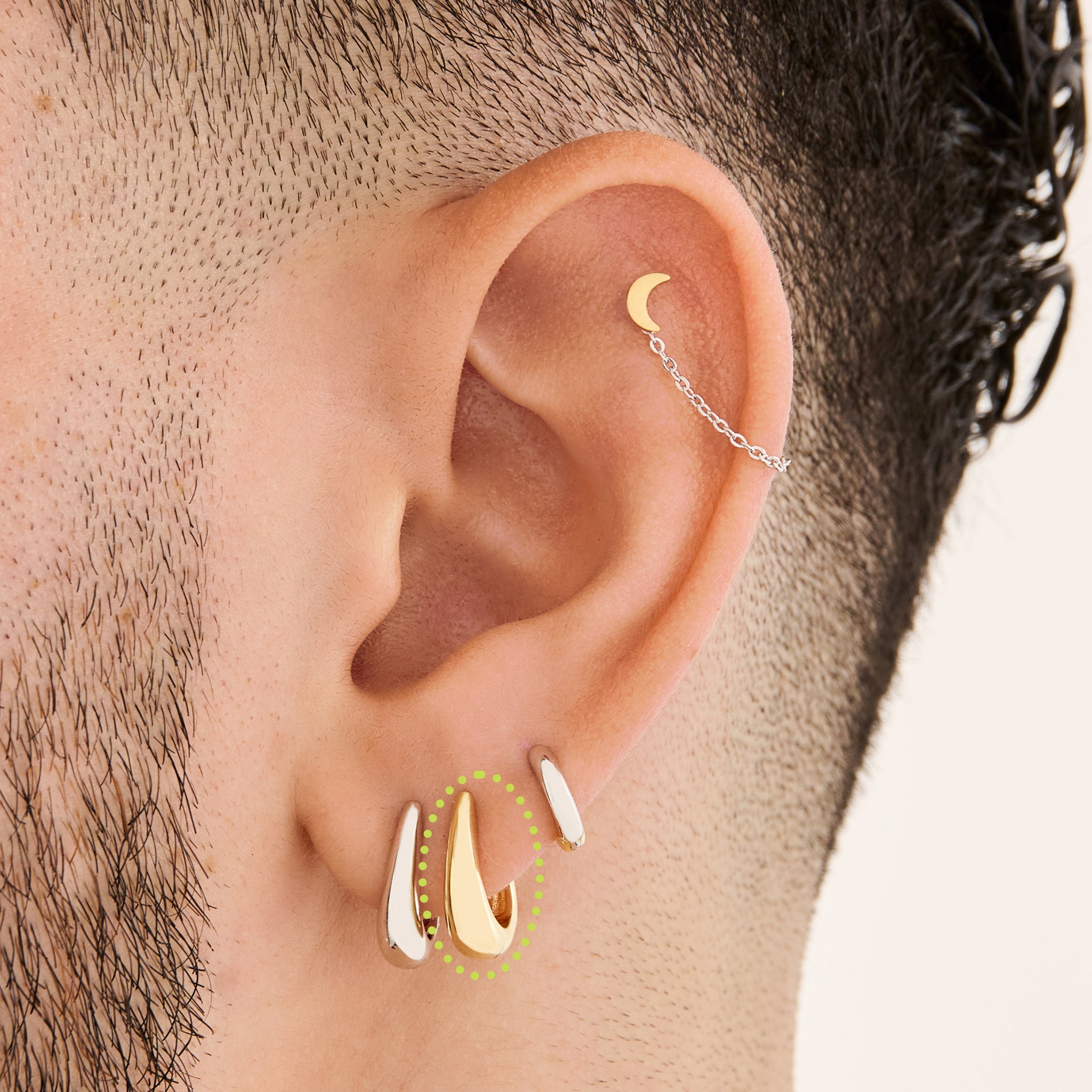 This is an image of a gold-toned, small, crescent shaped huggie on ear. [hover] color:null|gold