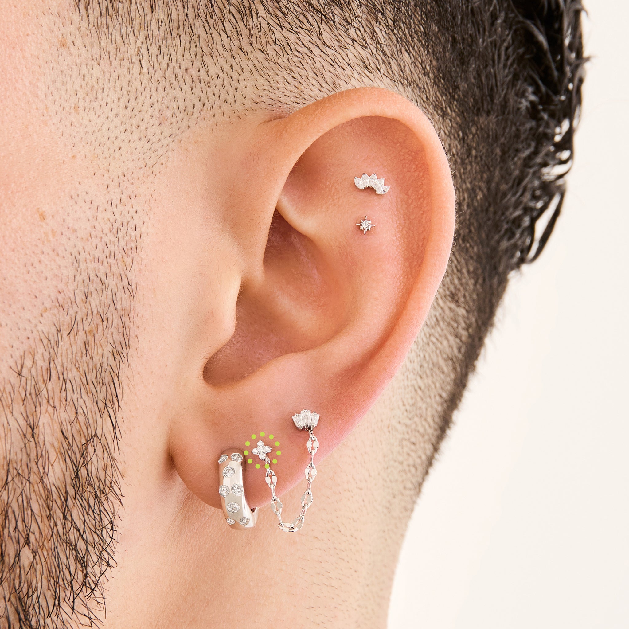 This is an image of a silver-toned flatback stud that has pave cz stones in the shape of an X on ear. [hover] color:null|silver/clear