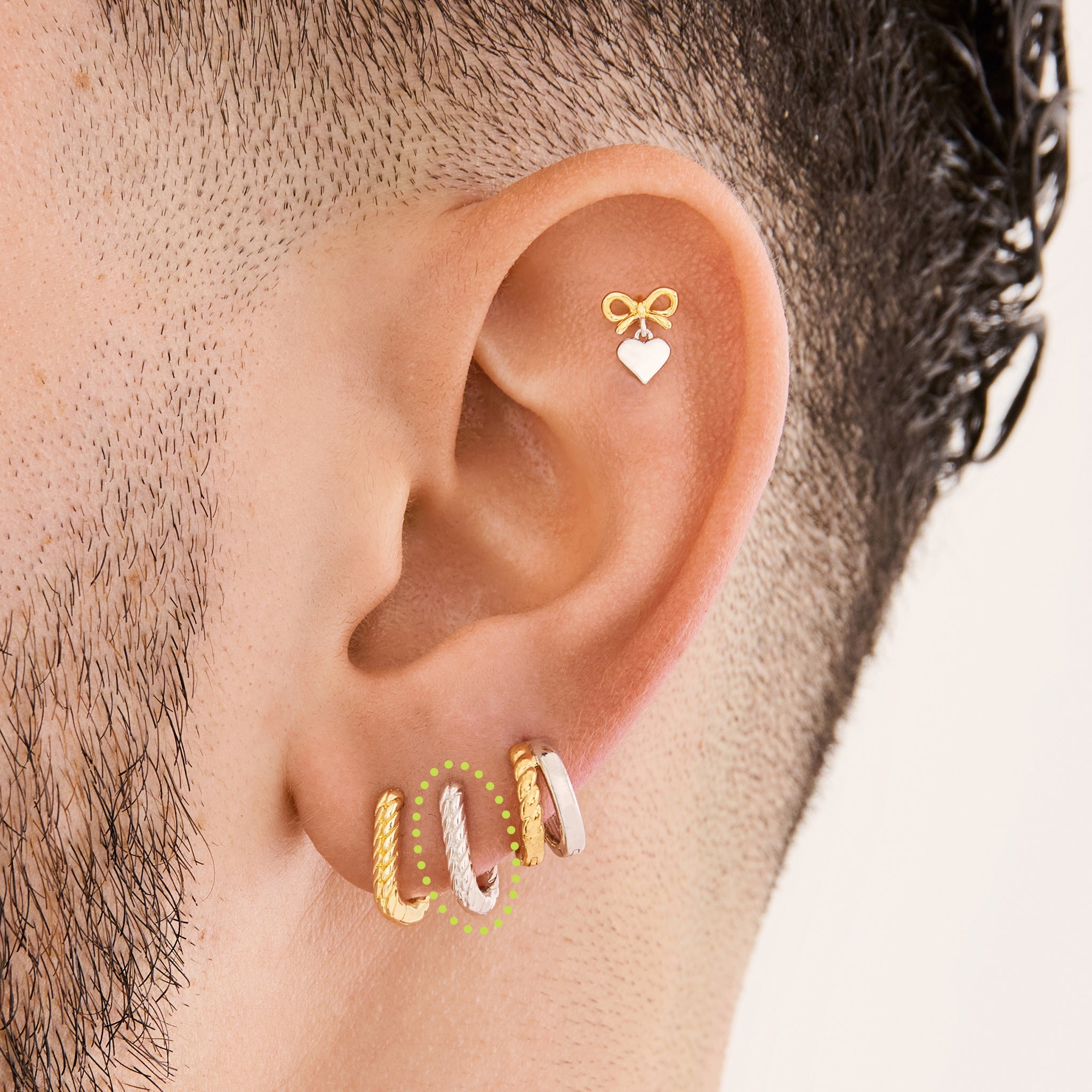 This is an image of a silver-toned, square shaped huggie that has twists throughout it on ear. [hover] color:null|silver