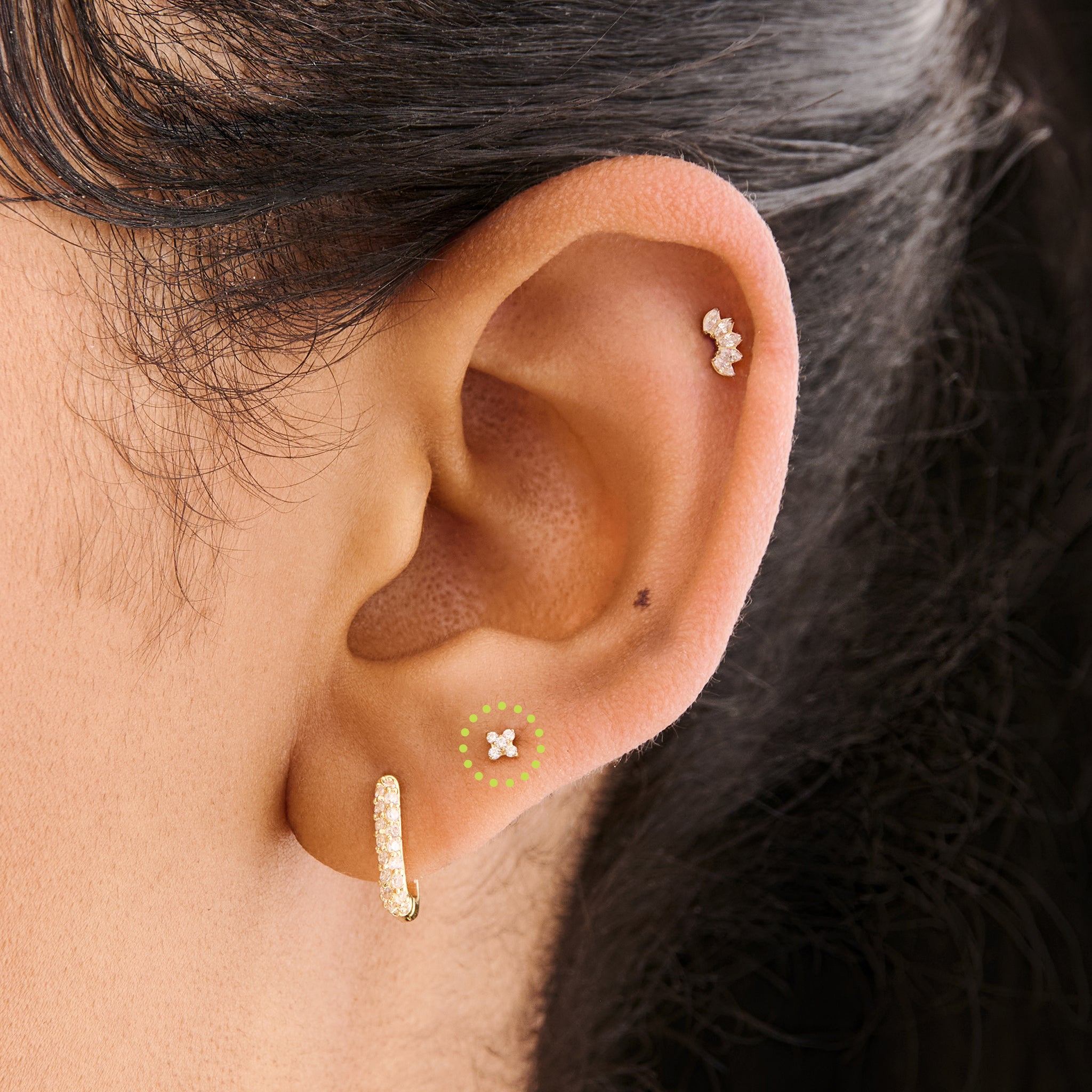 This is an image of a gold-toned flatback stud that has pave cz stones in the shape of an X on ear. [hover] color:null|gold/clear