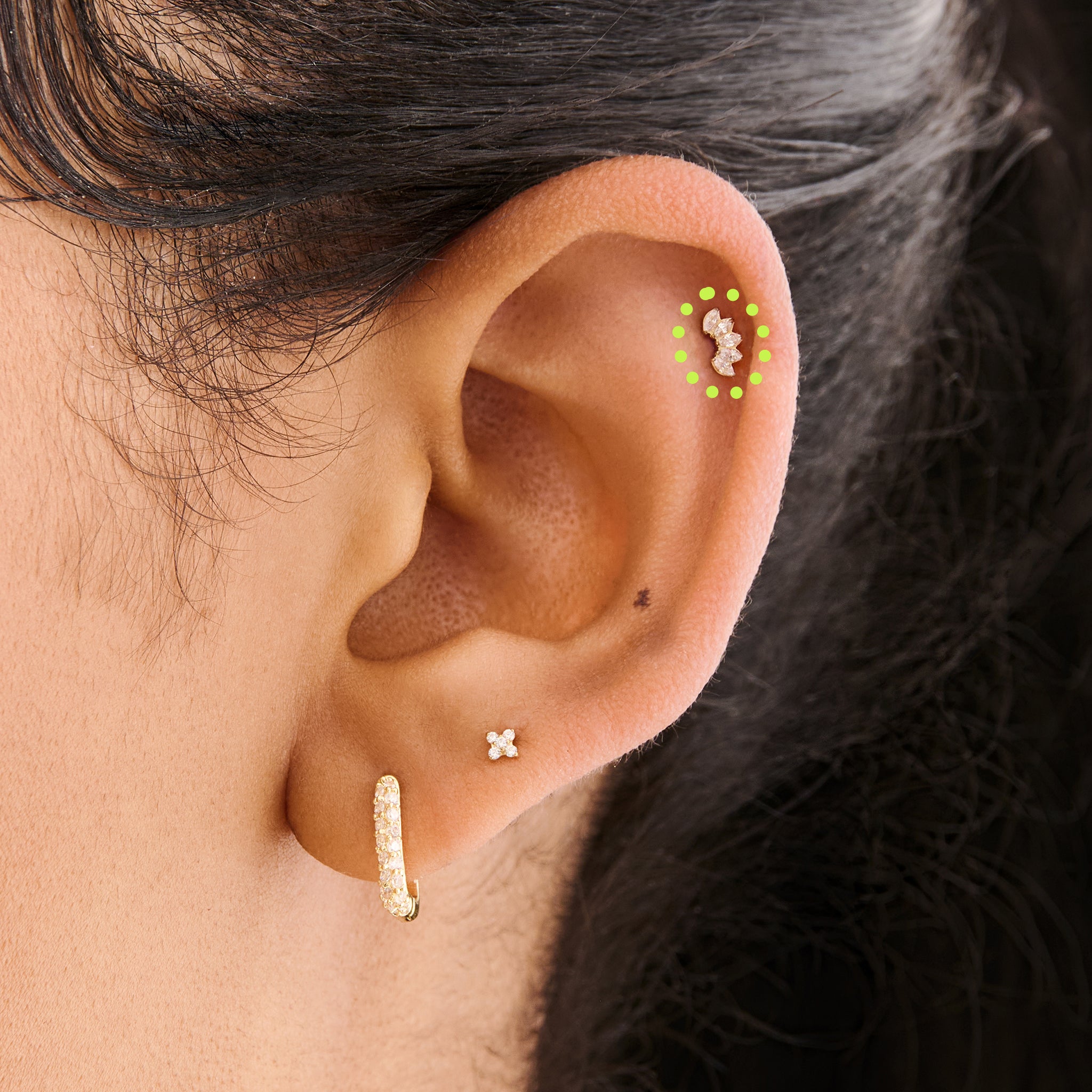 This is an image of a micro-sized gold toned stud with CZ's in a crown marquise shape on ear. [hover] color:null|gold/clear