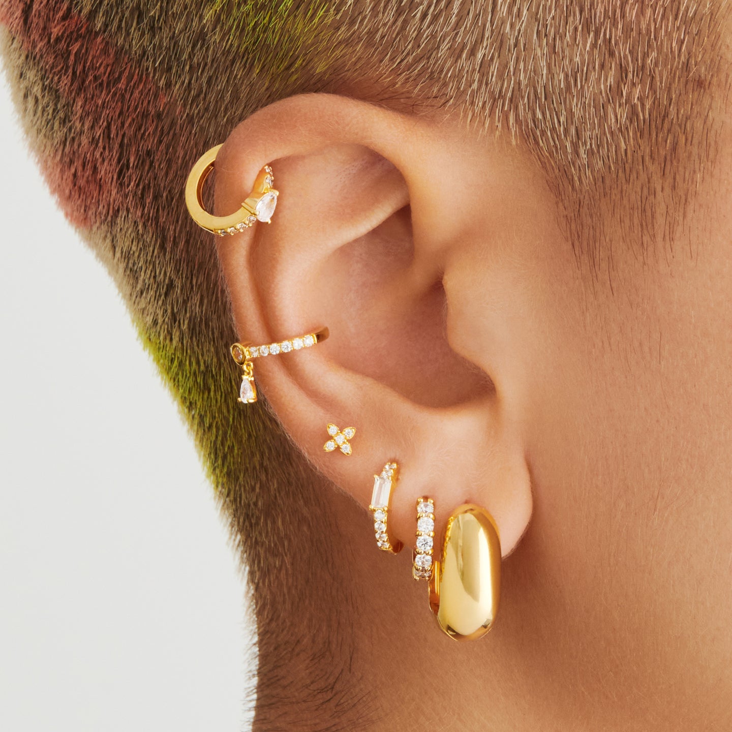 An image of a gold/clear pave huggie with max pave stones on ear. [hover] color:null|gold/clear