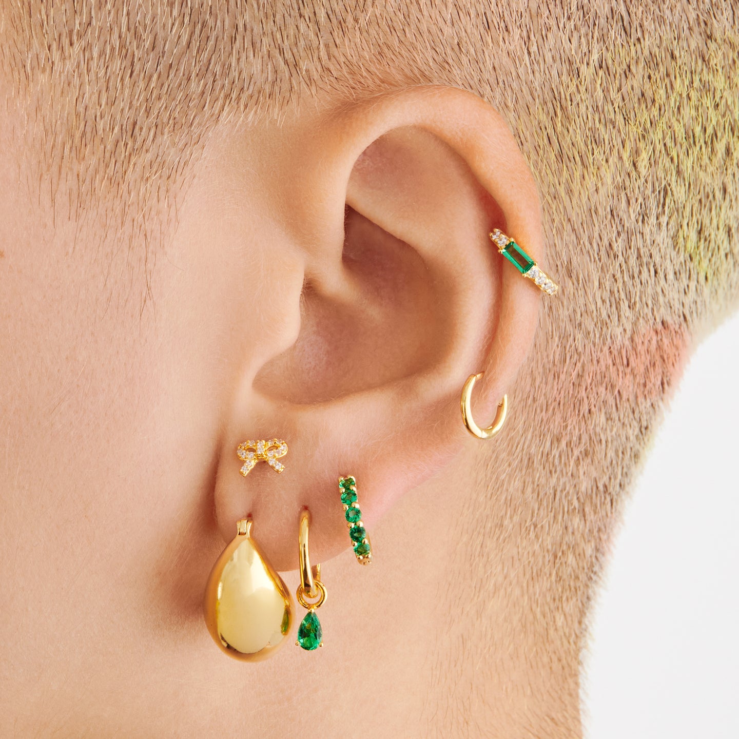 a gold small slim huggie with a pear shaped green cz charm on ear [hover] color:null|gold/green