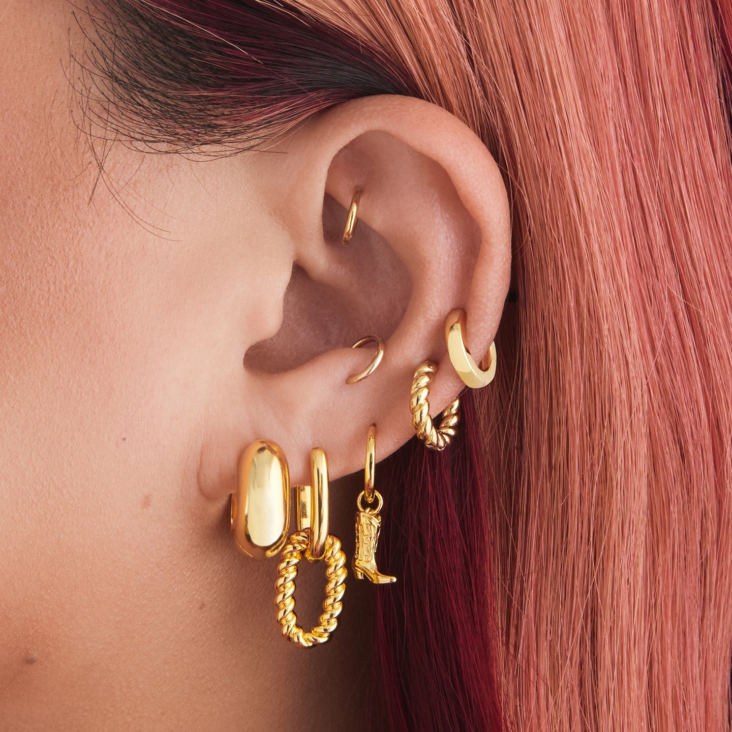 An image of a gold, chunky, square shaped huggie on ear. [hover] color:null|gold