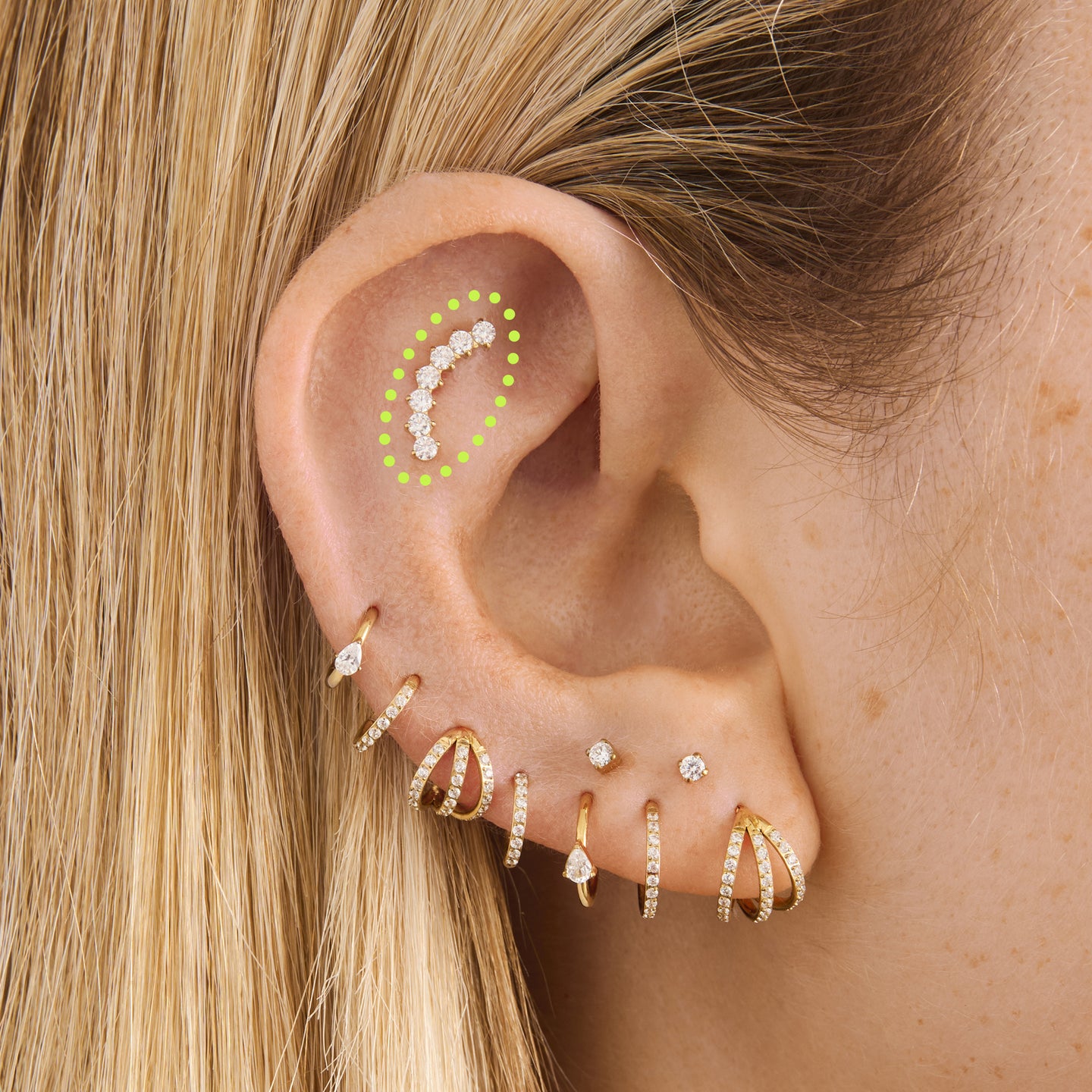 on ear featuring a flatback stud with a curved row of cz stones in gold [hover] color:null|gold/clear