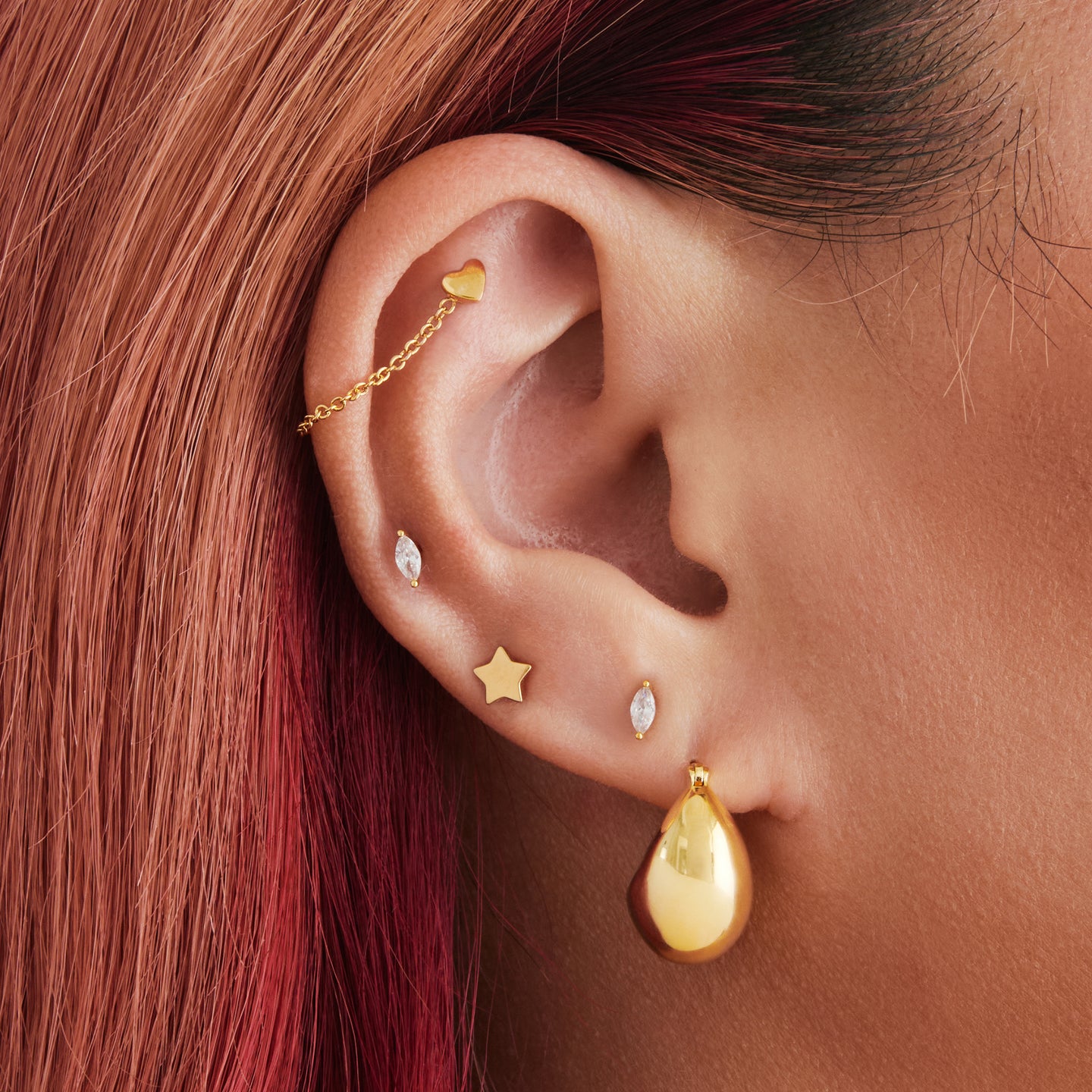 An image of a gold, small chunky crescent-shaped hoop on ear. [hover] color:null|gold