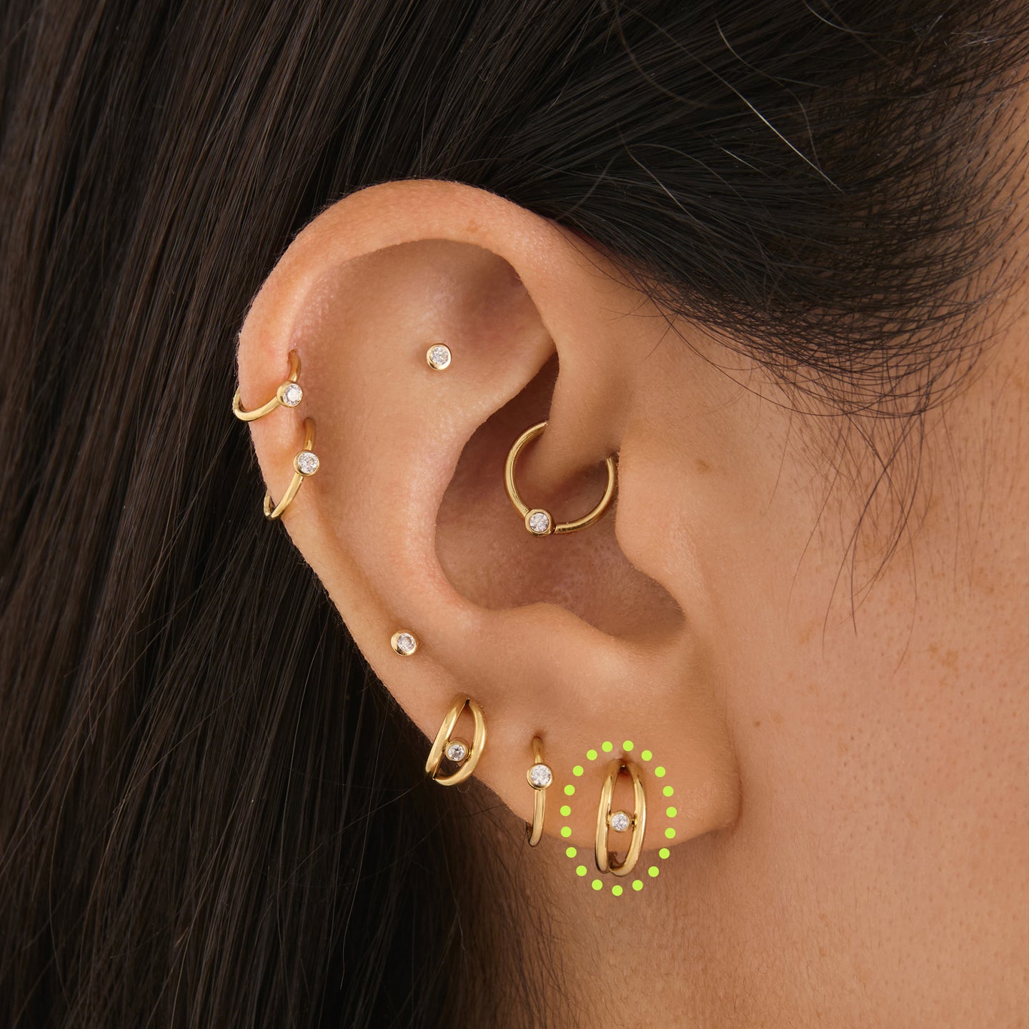 on ear featuring gold double clicker with a small bezel stone accent in gold [hover] color:null|gold/clear