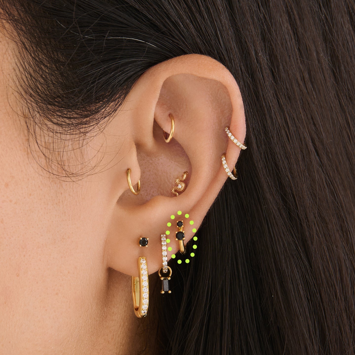 on ear featuring a micro huggie in gold with 2 mini black cz stones [hover] color:null|gold/black