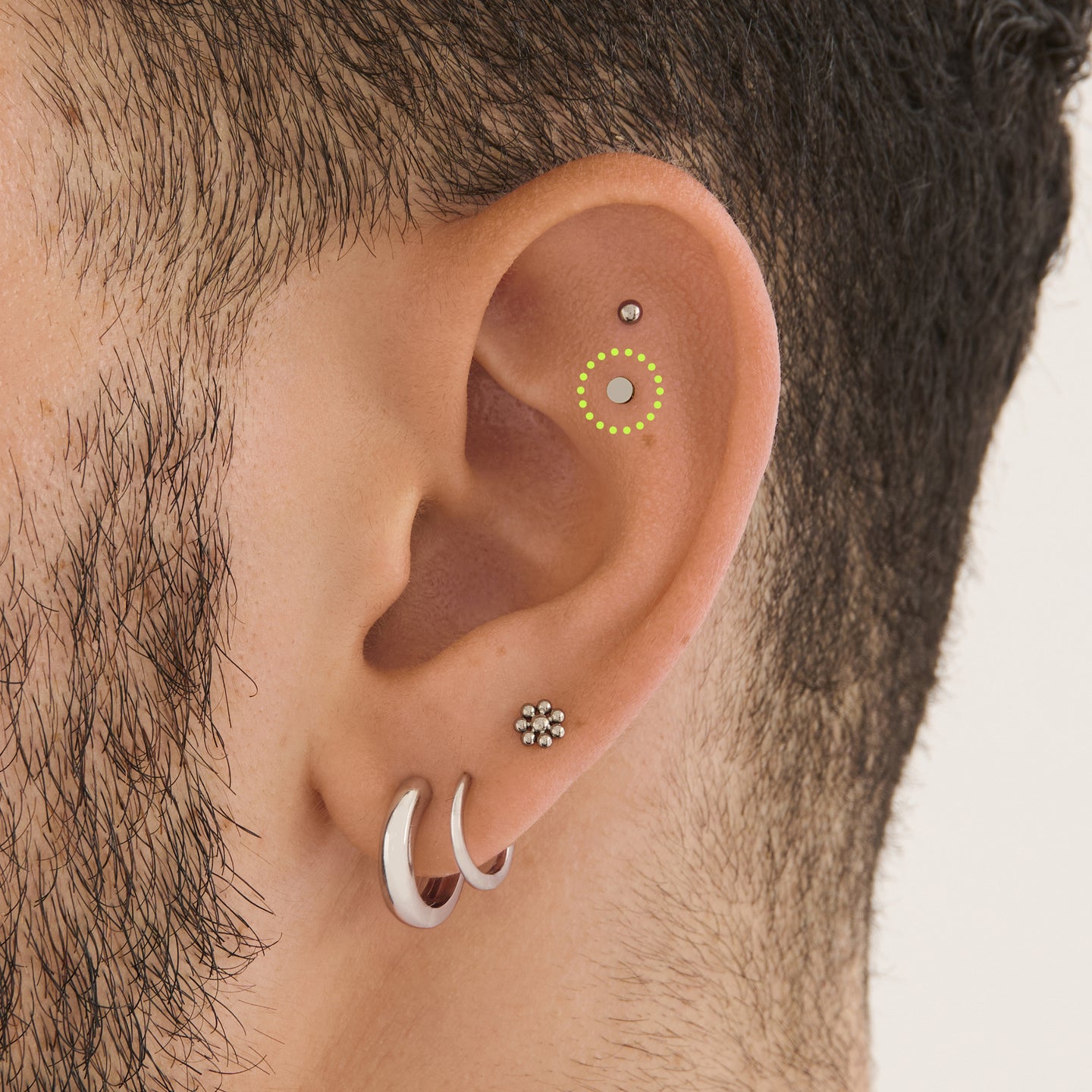 on ear featuring a small stud in the shape of a flat-topped circle made of titanium [hover] color:null|titanium