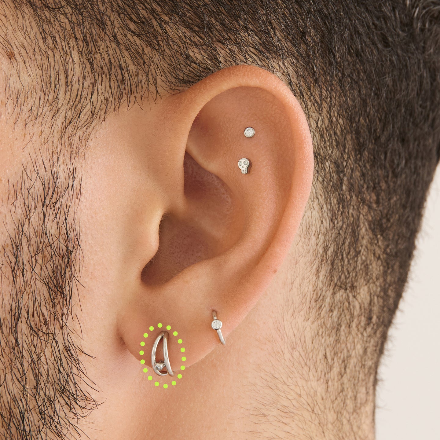 on ear featuring a silver double clicker with a small bezel stone accent in gold [hover] color:null|silver/clear