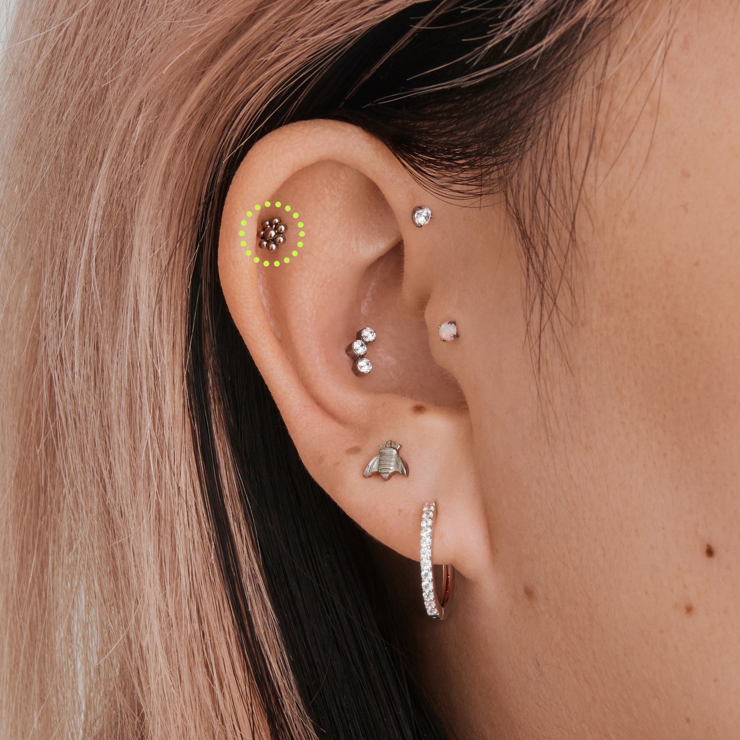 on ear featuring a small flower-shaped titanium flatback stud [hover] color:null|titanium