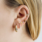 This image shows a 14k yellow gold pave martini flatback stud with a green cz stone on ear 