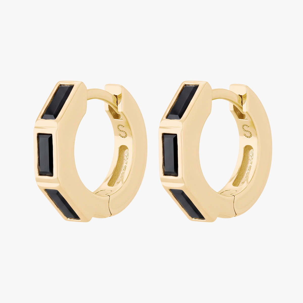 this image shows the side view of the 14k gold plated max bezel baguette huggie pair with black cz baguette stones. 