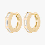 this image shows the side view of the 14k gold plated max bezel baguette huggie pair with clear cz baguette stones. 