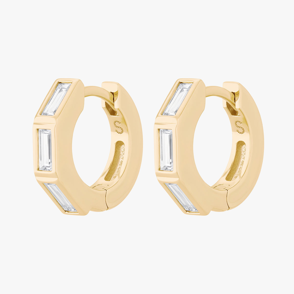 this image shows the side view of the 14k gold plated max bezel baguette huggie pair with clear cz baguette stones. 
