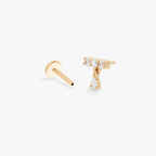 This image shows an image of a side view 14k Yellow gold pave bar flatback with cz dangle separated from labret