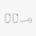 A silver earscape set featuring a pair of square pave huggies and a pave x flatback with clear stones